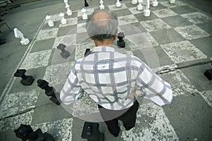 Old Man Playing Oversize Chess Board