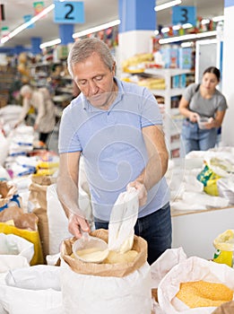 Old man purchaser buying sugar sand in supermarket