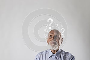 Old man and question marks. Dementia and ignorance. Confused old man