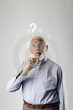 Old man and question marks. Dementia and ignorance. Confused old man