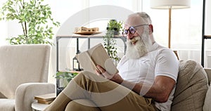 Old man reading a book at home