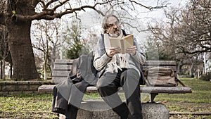 Old man reading book in the park