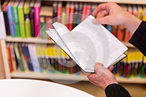 An Old Man Reading A Book And Turning page, In The Library.