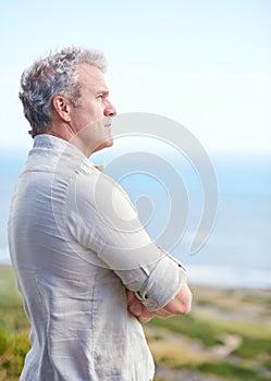 Old man, relax and thinking at beach in retirement with ideas for health, holiday and mindfulness. Mature, person and