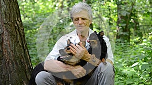 Old man resting in the forest with dogs