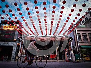 Old Man Riding Bicycle in front of an Asia Temple