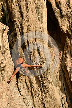 Old man rock climber without a net hanging in the cliff with his hands. Rai Leh or Railay, Phra Nang Beach, Krabi, Thailand. Sport