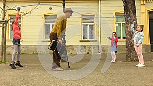 Old man rope skipping with three girls.