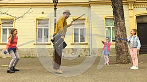 Old man rope skipping with three girls.