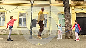 Old man rope skipping with three girls.