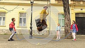 Old man rope skipping with three girls.