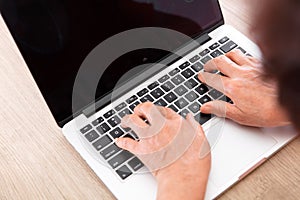 Old man`s hand typing input on a computer keyboard