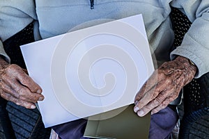 Old man`s hands holding blank card