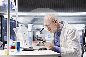 Old man scientist using microscope instrument in clinical research study