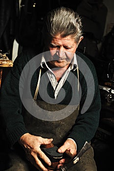 Old man, shoemaker, repairing old handmade