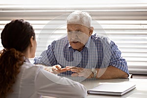 Old man sit by doctor desk complain on bad health