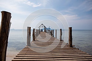 The old man sits on the pier and looks at the sea