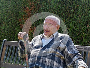 Old man sitting on a bench in the garden