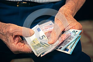 Old man sitting at home counting her money