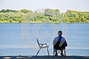 Old Man Sitting on River Bank
