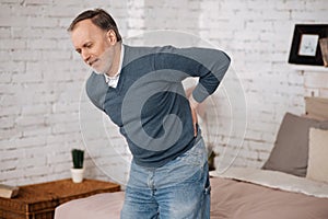 Old man standing with backache