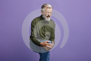 Old man suffering from knee pain isolated on blue background