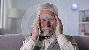 Old man suffering migraine, symptom of ischemic stroke, neurological problems