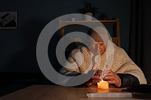 Old man suffers in no heating and no electricity during an energy crisis causing blackouts. No heating.