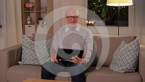 Old man with tablet pc having video call at home