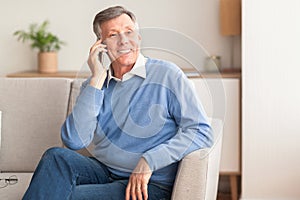 Old Man Talking On Cellphone Sitting On Sofa At Home