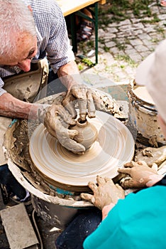 Old man teaching child to make pottery