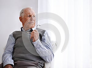 Old man, thinking and lonely for depression on couch, glasses and remember memories or mistake. Senior male person