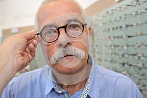 Old man trying pair eyeglasses