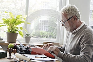 Old man typing on a typewriter