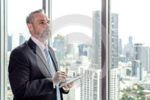 Old man use tablet in his office working in rooftop meeting room