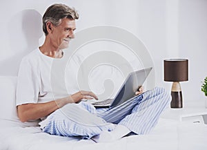 Old Man Using Laptop while Sitting in Bed.