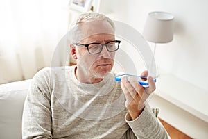 Old man using voice command recorder on smartphone