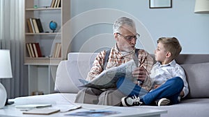 Old man veteran viewing map with grandson showing front line, remembering war