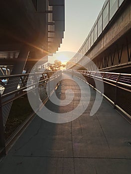 An old man is walking on the road at sunset.