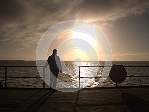 Old man watch the morning sea over pier handrail