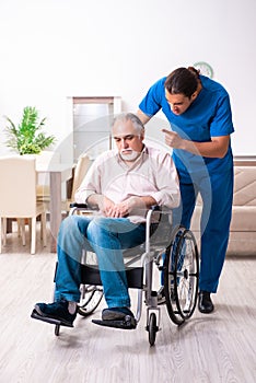 Old man in wheel-chair and young bad caregiver indoors