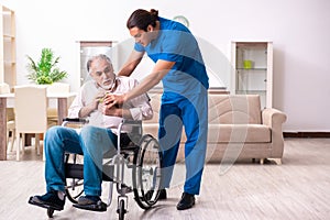 Old man in wheel-chair and young bad caregiver indoors