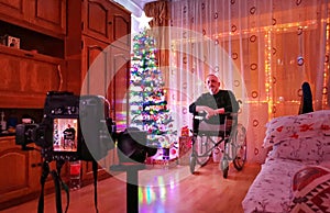 Old man in a wheelchair caught during a photo shoot on Christmas night