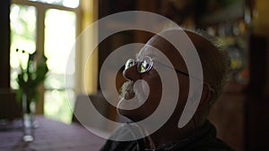 Old man in a wheelchair watching tv in the livingroom at home