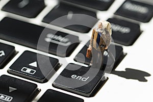 Old man on white notebook keyboard. Computer keyboard closeup with focus on End button.