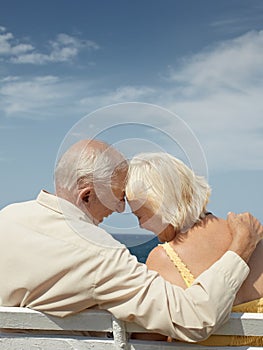 Old man and woman on bench at the sea