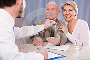 Old man and woman sign rent agreement