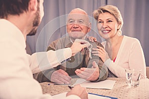 Old man and woman sign rent agreement