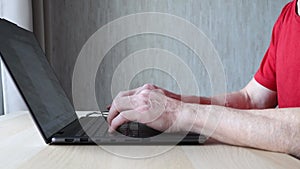 Old man working on computer. Senior man typing on laptop keyboard