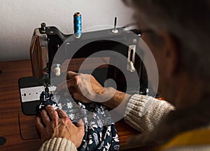 Old man working at the sewing machine